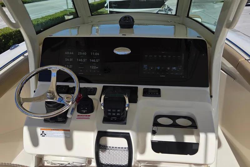 Slide: The Image of 2021 Scout 305 LXF boat dashboard with steering wheel and digital displays. - 13