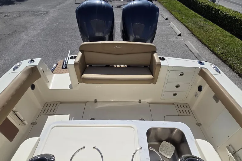 Slide: The Image of 2021 Scout 305 LXF boat interior with seating and dual outboard motors. - 14