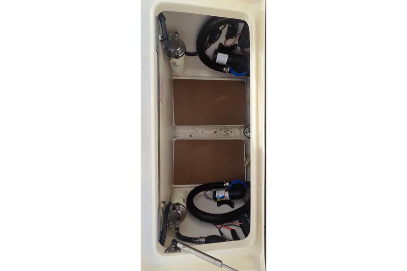 Slide: The Image of 2021 Scout 305 LXF boat storage compartment with wiring and components. - 16