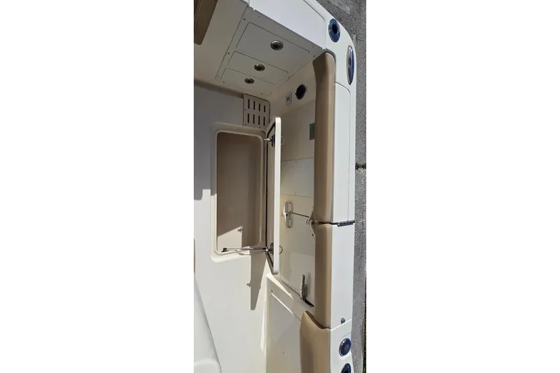 Slide: The Image of 2021 Scout 305 LXF boat interior with storage compartment and beige accents. - 17