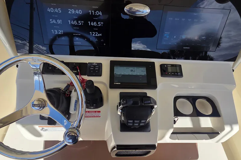 Slide: The Image of 2021 Scout 305 LXF boat dashboard with steering wheel and digital displays. - 32