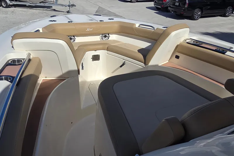 Slide: The Image of 2021 Scout 305 LXF boat interior with tan seating and cup holders. - 7