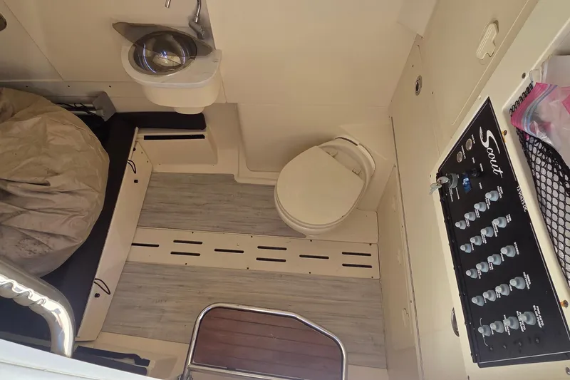 Slide: The Image of 2021 Scout 305 LXF boat interior with toilet, sink, and control panel. - 8