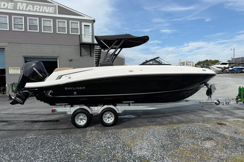 The Image of 2026 Bayliner VR6 Bowrider OB on trailer, parked outside a marine building. - 0