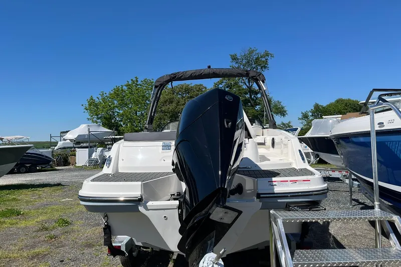 Slide: The Image of 2026 Bayliner VR6 Bowrider OB with outboard motor, parked outdoors on a sunny day. - 7