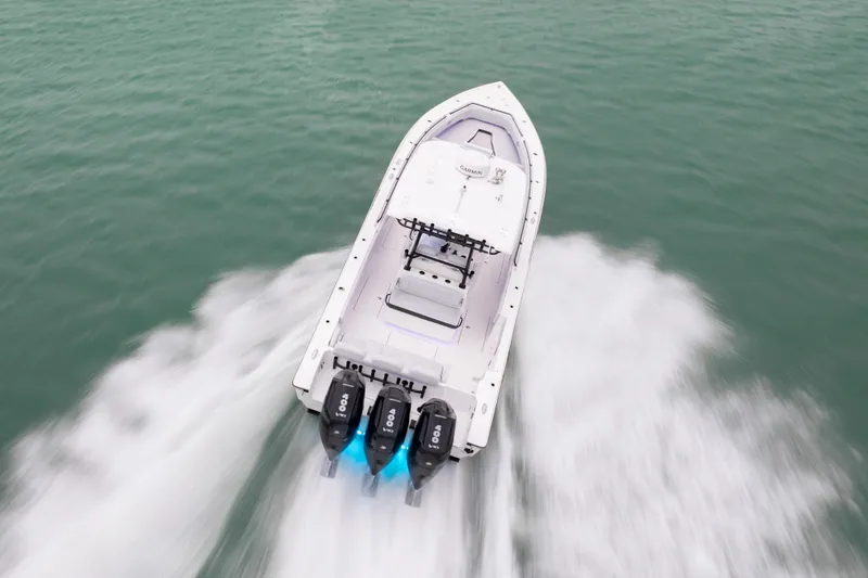Slide: The Image of 2025 Fountain 38 Center Console boat speeding on water with triple outboard engines. - 3