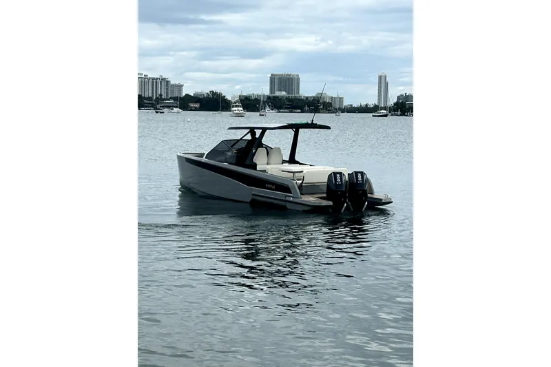 Slide: The Image of A 2026 Virtue V10 boat on a calm waterway with cityscape background. - 125