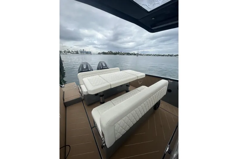 Slide: The Image of Luxury Virtue V10 boat interior with white seating, overlooking a calm waterfront. - 142