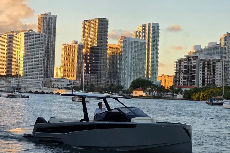 Slide: The Image of 2026 Virtue V10 boat on calm water with city skyline in background. - 46