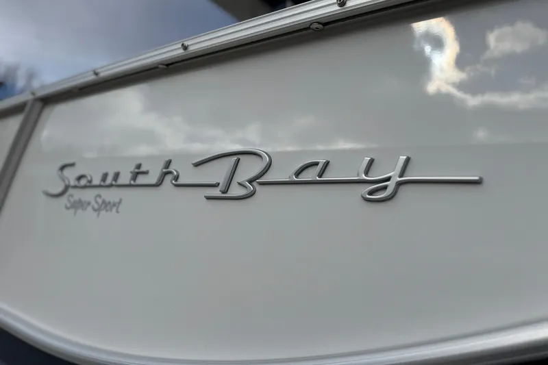 Slide: The Image of 2022 South Bay 25 Sport RS9-DC boat logo with cloudy sky reflection. - 12