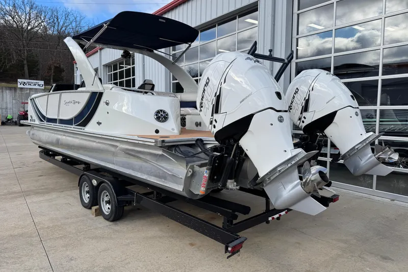 Slide: The Image of 2022 South Bay 25 Sport RS9-DC pontoon boat with dual outboard motors on a trailer. - 4