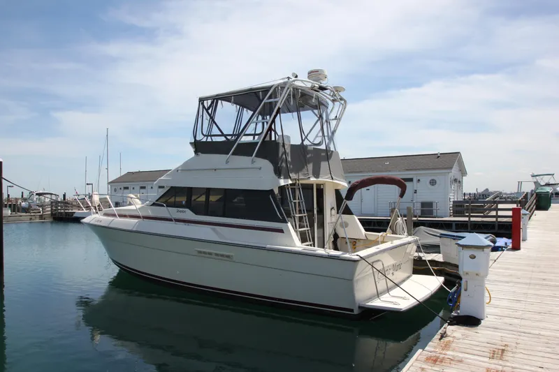 The Image of 1990 Silverton 34 Convertible boat docked at marina under clear sky. - 0