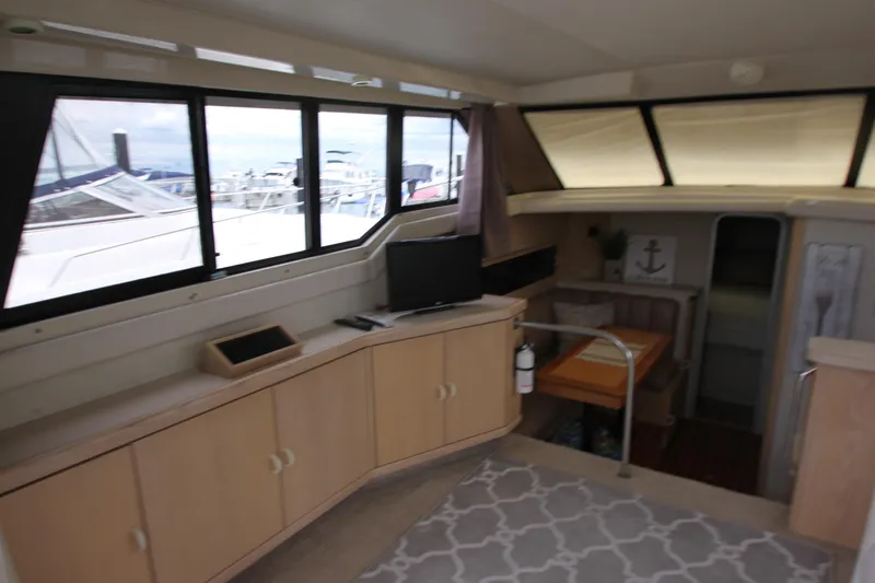 Slide: The Image of Interior of 1990 Silverton 34 Convertible yacht with modern furnishings and large windows. - 12