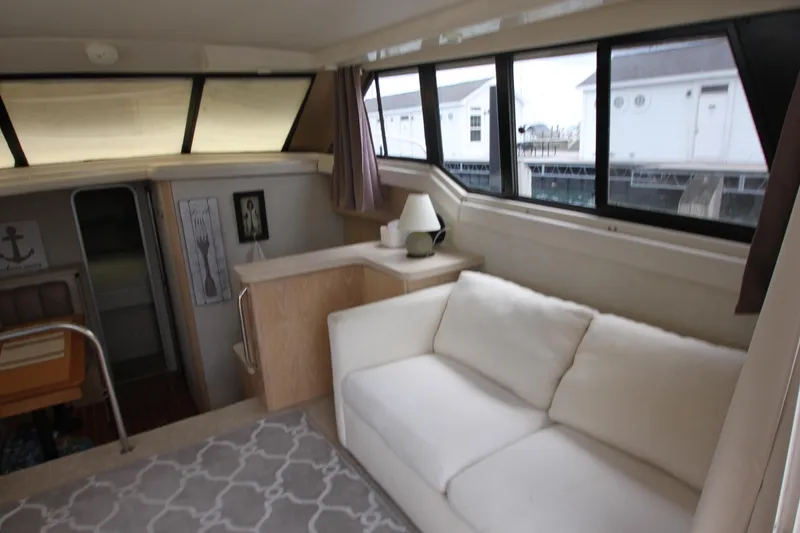 Slide: The Image of Interior of 1990 Silverton 34 Convertible yacht with white sofa and nautical decor. - 13