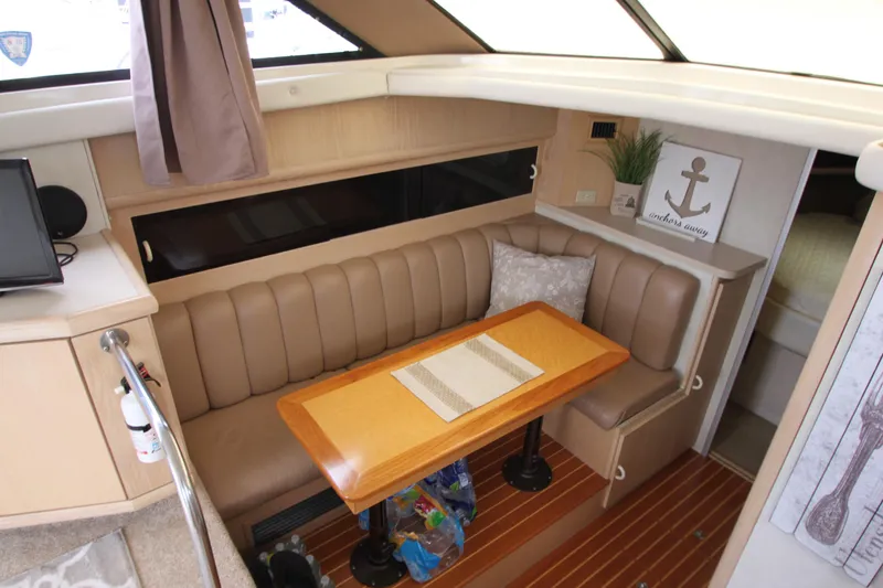 Slide: The Image of Interior of 1990 Silverton 34 Convertible yacht with dining area and wooden table. - 16