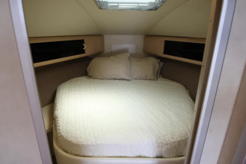 Slide: The Image of 1990 Silverton 34 Convertible cabin interior with cozy bed and overhead window. - 19