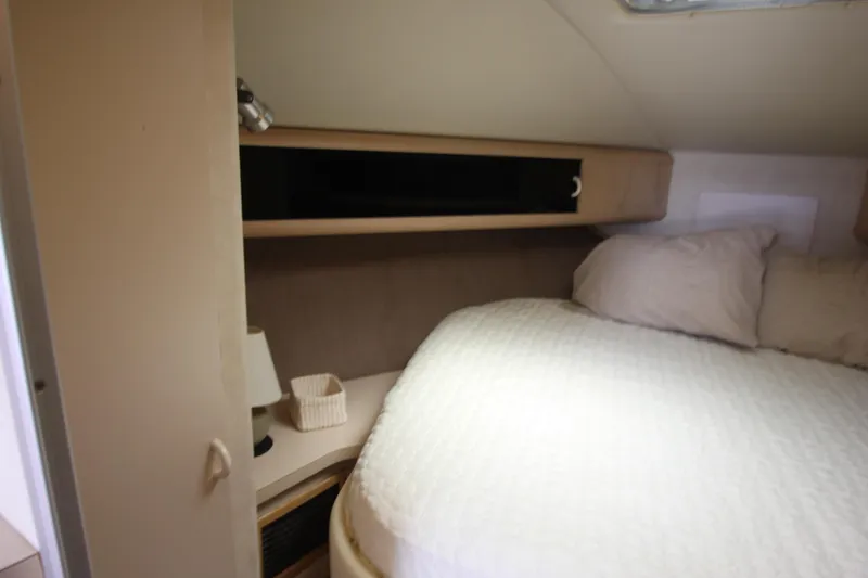 Slide: The Image of 1990 Silverton 34 Convertible cabin interior with bed and storage shelves. - 20