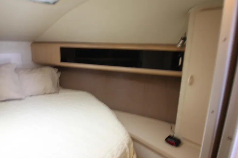 Slide: The Image of 1990 Silverton 34 Convertible cabin interior with bed and storage shelves. - 21