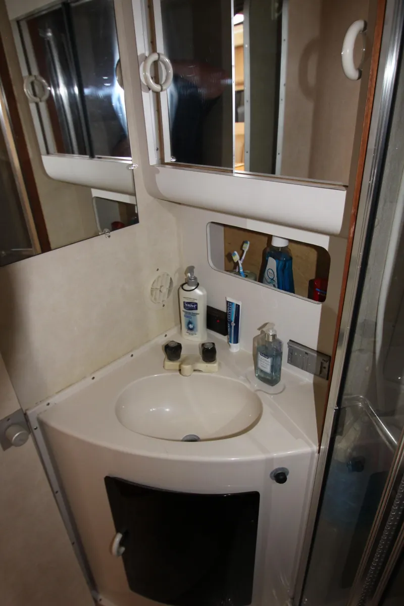 Slide: The Image of 1990 Silverton 34 Convertible bathroom with sink, mirror, and storage cabinets. - 29