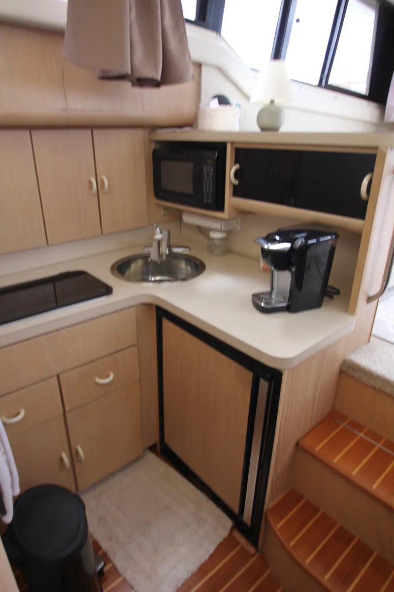 Slide: The Image of 1990 Silverton 34 Convertible yacht kitchen with sink, microwave, and coffee maker. - 32