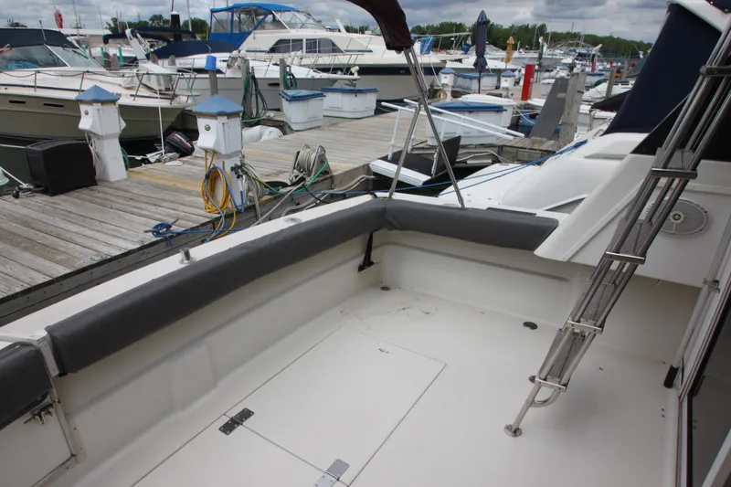 Slide: The Image of 1990 Silverton 34 Convertible boat docked at marina, featuring spacious deck area. - 36