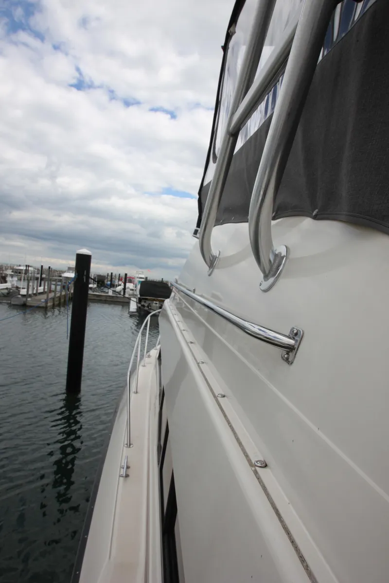 Slide: The Image of 1990 Silverton 34 Convertible boat docked at marina under cloudy sky. - 4