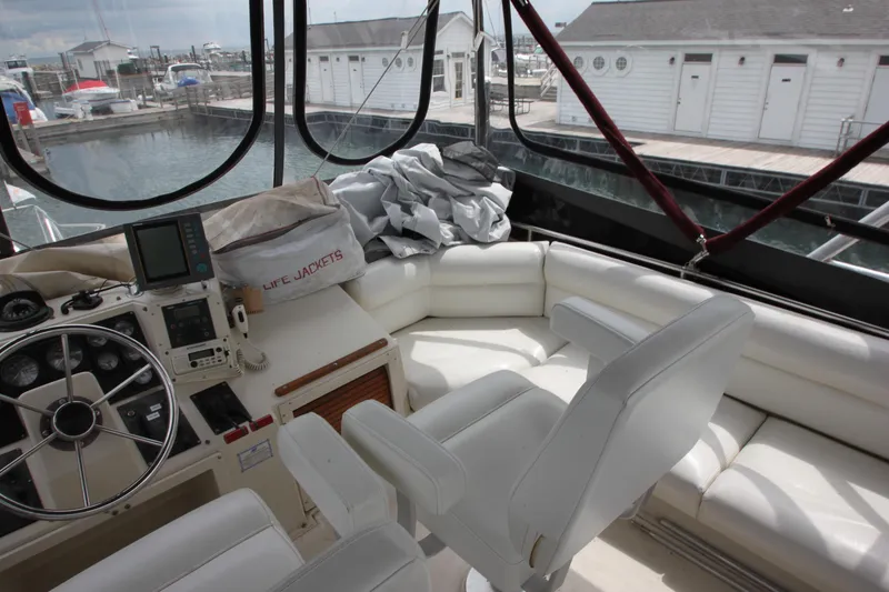 Slide: The Image of 1990 Silverton 34 Convertible yacht interior with white seating and navigation equipment. - 43