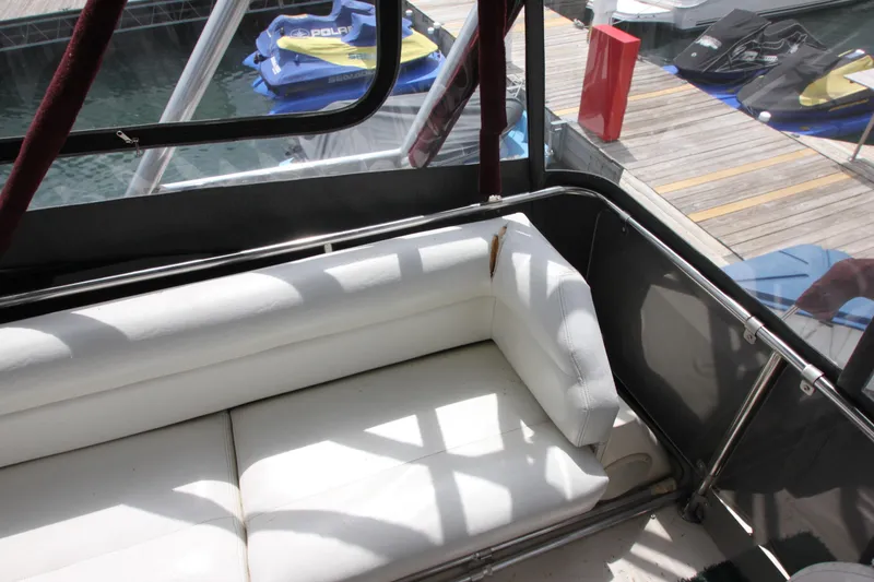 Slide: The Image of 1990 Silverton 34 Convertible boat with white seating, dockside view, and watercraft in background. - 46