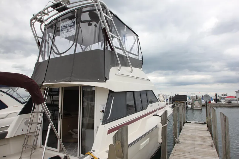 Slide: The Image of 1990 Silverton 34 Convertible yacht docked at marina under cloudy skies. - 6