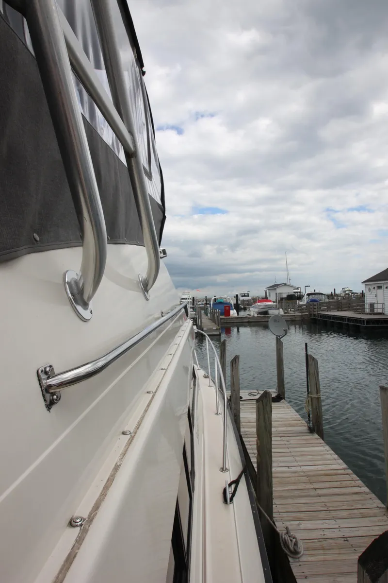Slide: The Image of 1990 Silverton 34 Convertible yacht docked at a marina under cloudy skies. - 7