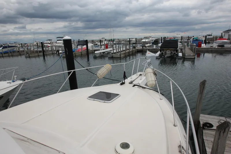 Slide: The Image of 1990 Silverton 34 Convertible yacht docked at a marina under cloudy skies. - 8