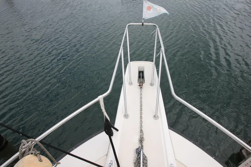 Slide: The Image of Bow view of 1990 Silverton 34 Convertible boat with anchor chain and flag. - 9