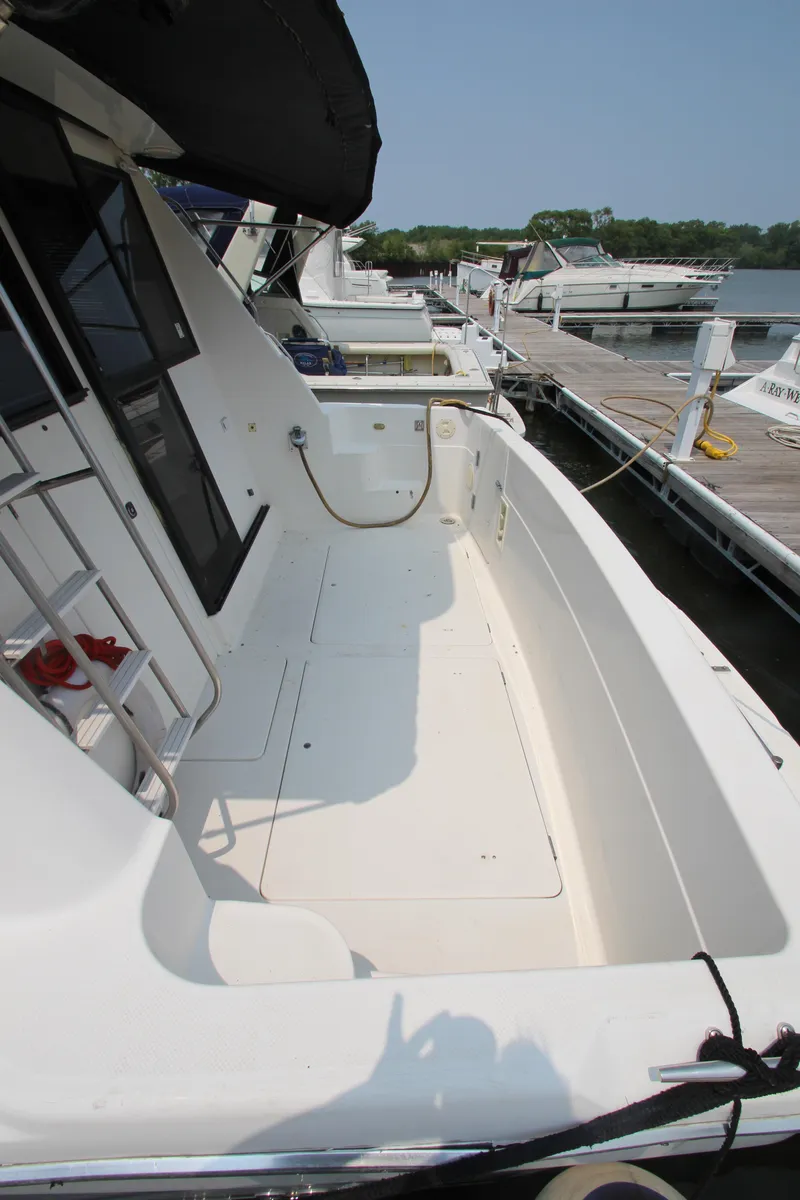 Slide: The Image of 1996 Bayliner 3988 Command Bridge Motoryacht docked, showcasing spacious deck and sleek design. - 10