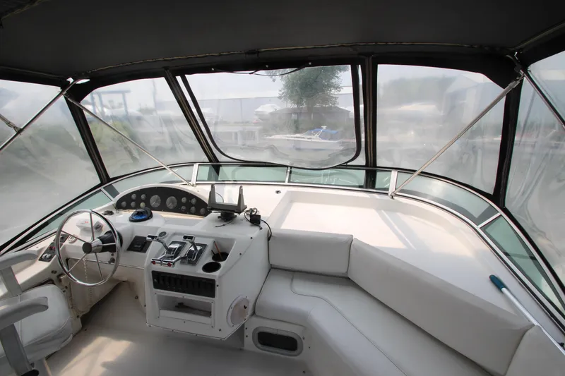 Slide: The Image of 1996 Bayliner 3988 Command Bridge Motoryacht helm with panoramic windows and modern controls. - 13