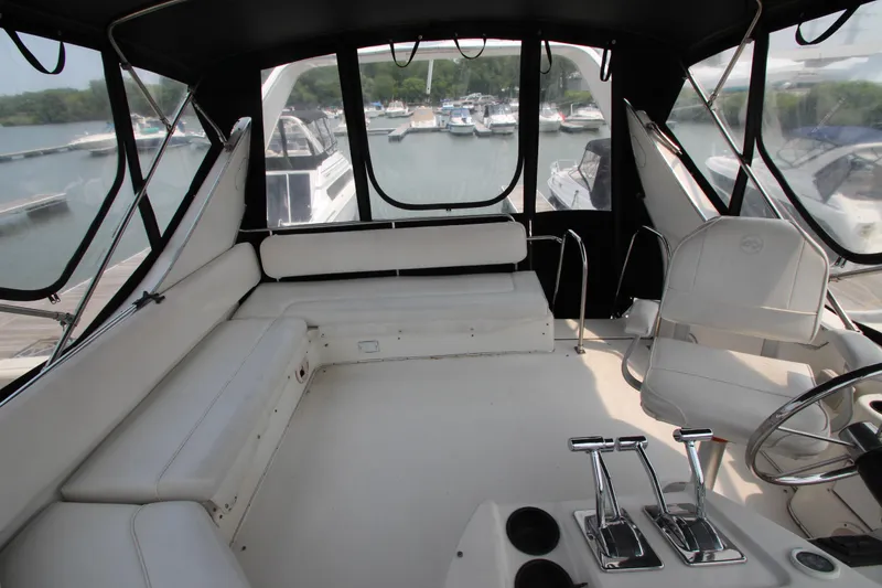 Slide: The Image of 1996 Bayliner 3988 Command Bridge Motoryacht interior with helm, seating, and marina view. - 15