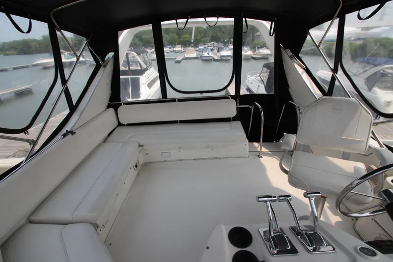 Slide: The Image of 1996 Bayliner 3988 Command Bridge Motoryacht interior with white seating and helm controls. - 16