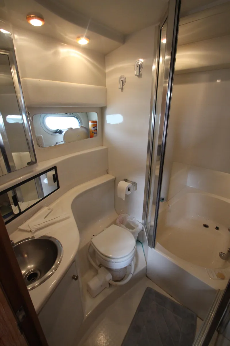 Slide: The Image of Bathroom interior of 1996 Bayliner 3988 Command Bridge Motoryacht, featuring sink, toilet, and shower. - 26