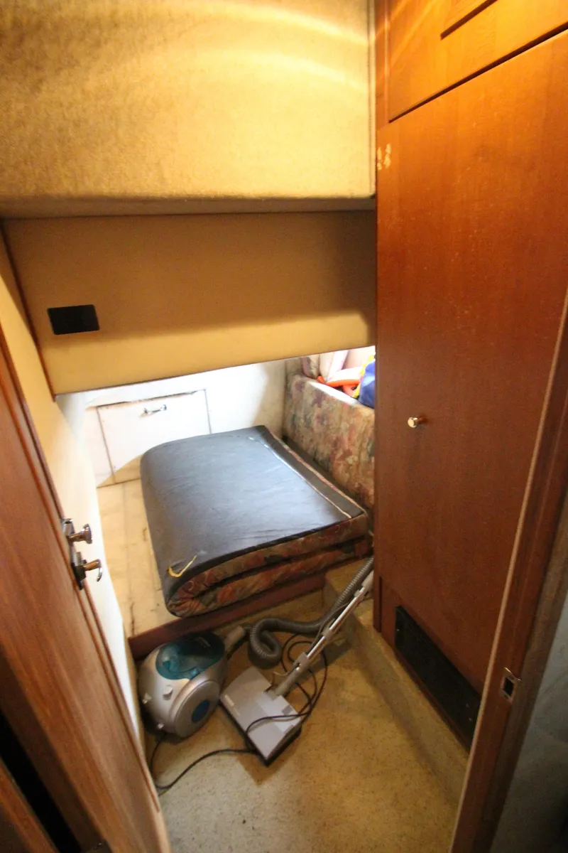 Slide: The Image of 1996 Bayliner 3988 Command Bridge Motoryacht interior with bed and vacuum cleaner. - 33