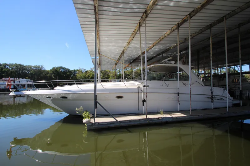 The Image of 2001 Sea Ray 460 Sundancer yacht docked under a covered marina. - 0