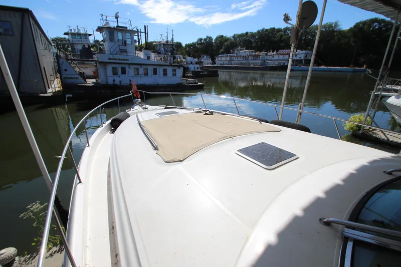 Slide: The Image of 2001 Sea Ray 460 Sundancer docked in a marina, surrounded by boats and calm water. - 14