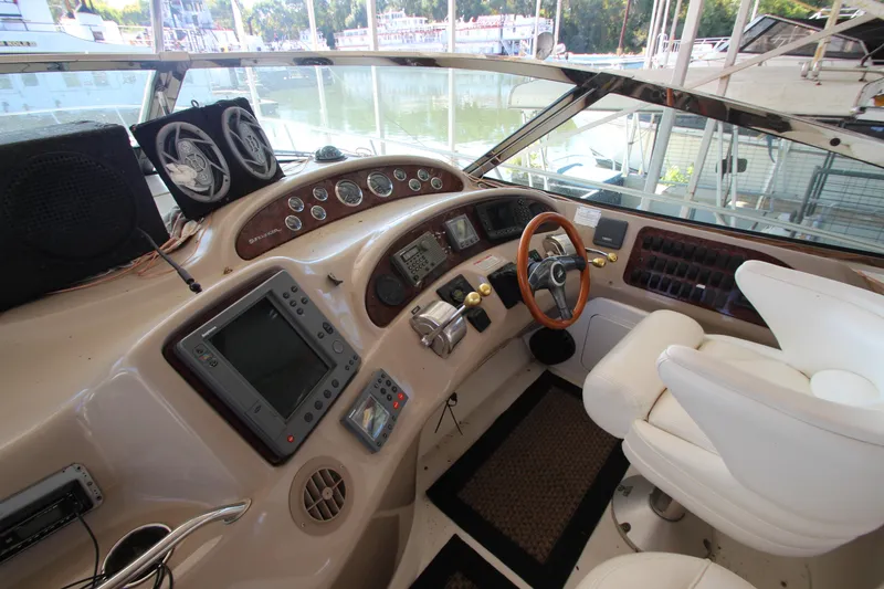 Slide: The Image of 2001 Sea Ray 460 Sundancer helm with modern navigation equipment and white captain's chairs. - 25