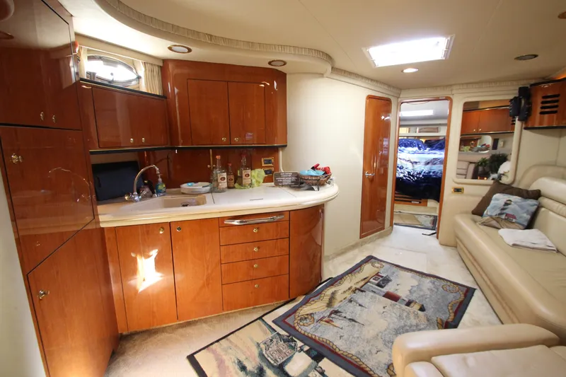 Slide: The Image of Luxurious 2001 Sea Ray 460 Sundancer yacht interior with elegant wood cabinetry and cozy seating. - 30