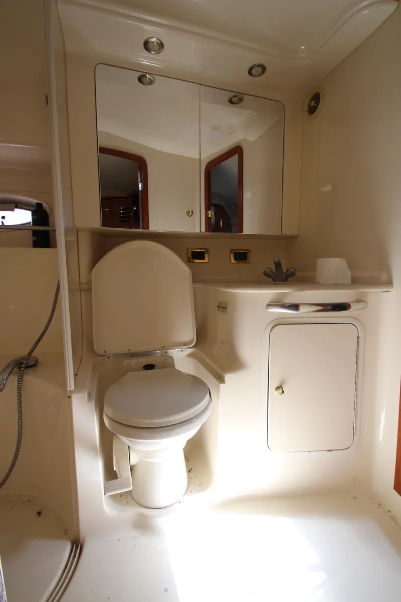 Slide: The Image of 2001 Sea Ray 460 Sundancer bathroom with toilet, mirror, and storage cabinet. - 35