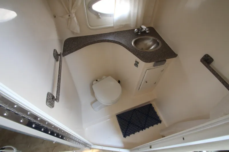 Slide: The Image of 2005 Rinker 312 Fiesta Vee boat bathroom with toilet, sink, and window. - 16