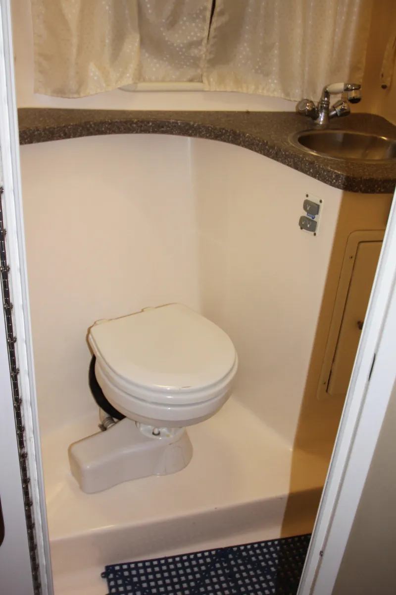 Slide: The Image of Compact bathroom in 2005 Rinker 312 Fiesta Vee boat with toilet and sink. - 19