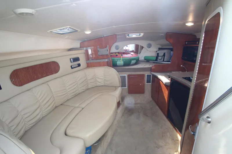 Slide: The Image of Interior of 2005 Rinker 312 Fiesta Vee boat with beige seating and wooden cabinetry. - 21