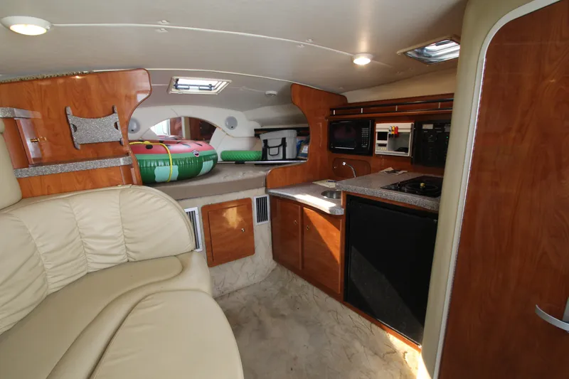 Slide: The Image of Interior of 2005 Rinker 312 Fiesta Vee boat with kitchenette and seating area. - 22