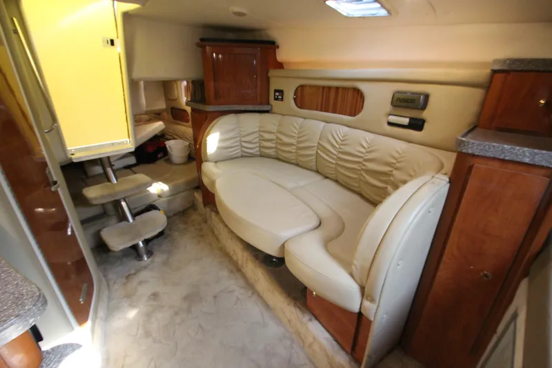 Slide: The Image of 2005 Rinker 312 Fiesta Vee cabin interior with beige leather seating and wooden cabinetry. - 32