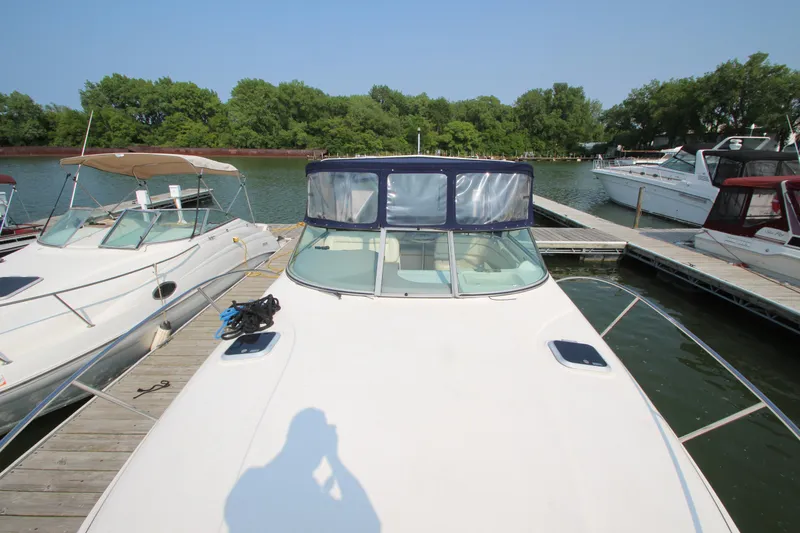 Slide: The Image of 2005 Rinker 312 Fiesta Vee docked at a marina with other boats. - 4