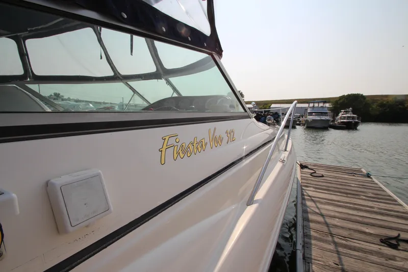 Slide: The Image of 2005 Rinker 312 Fiesta Vee boat docked at a marina. - 6
